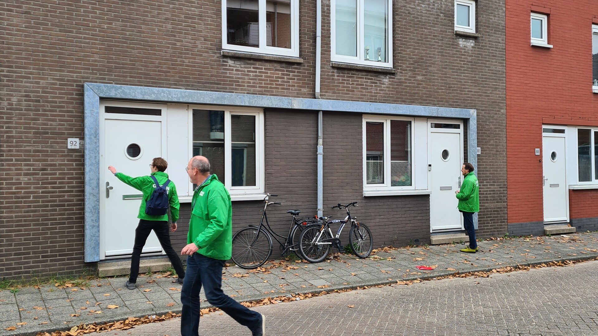 Mensen in GroenLinks-jassen lopen door Korte Akkeren