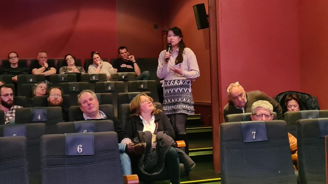 Groep mensen in filmzaal bij avond over armoede