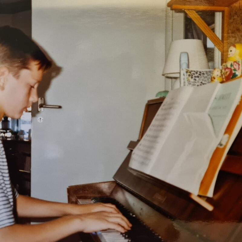 Tim Geluk als kind achter de piano
